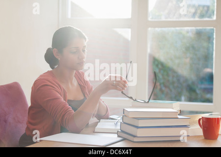 Young woman studying books at desk Stock Photo
