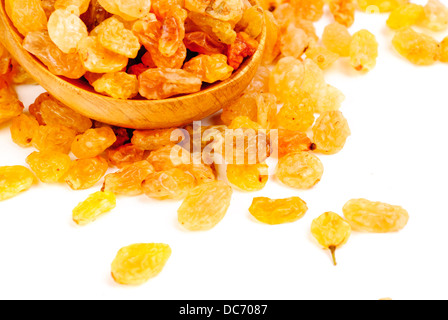 Golden raisins close- up and wooden spoon, isolated on white background Stock Photo