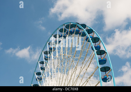 Large ferris wheel against a blue cloudy sky. The gondoliers are empty Stock Photo