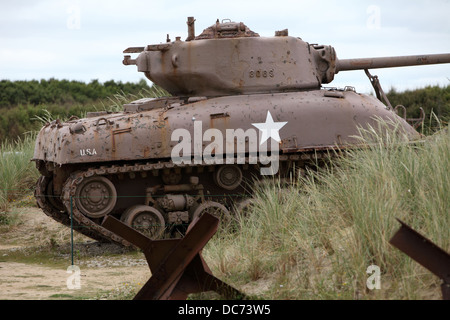 Sherman Tank abandoned at Utah Beach, Normandy, now a memorial to those who died liberating France. Tank traps in the foreground Stock Photo