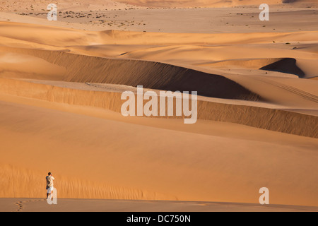 Tourist photographing sand dunes near Swakopmund, Dorob national park, Namibia, April 2013