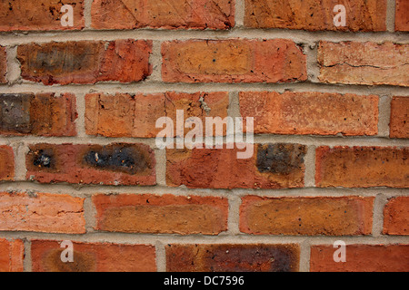 Red / brown colored brick wall with cement in between Stock Photo