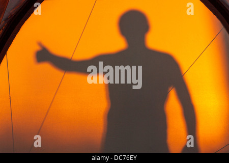 Silhouette of man gesturing ok reflected on a tent Stock Photo