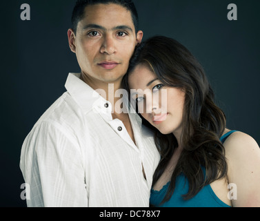 Mixed race Beautiful Couple asian american woman resting head on latino man's chest / shoulder Stock Photo