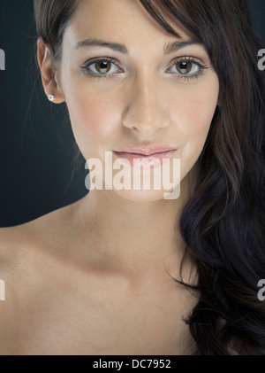 Studio portrait of beautiful young woman with long brown hair. Stock Photo