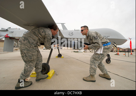 US Air Force airmen load a missile onto a MQ-1 Predator unmanned aerial drone April 5, 2013 at Holloman Air Force Base, NM. Stock Photo