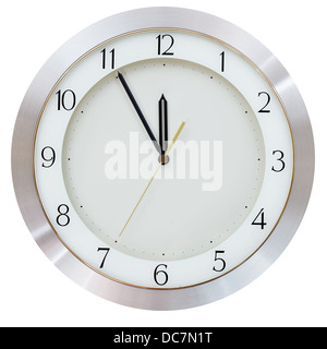 at five minutes to twelve on the dial round wall clock Stock Photo
