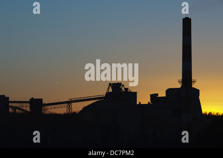 Silhouetted sunset view of industrial plant Stock Photo