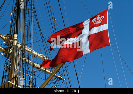 The official swallow-tailed Danish flag, the Dannebrog, on old tall ship, the Danish training ship DANMARK moored in Copenhagen Stock Photo