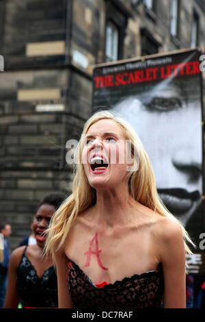 Edinburgh, UK. 11th Aug, 2013. Actors from the Livewire Theatre perform on the Royal Mile enticing people to attend their performance of The Scarlet Letter between 11-17 August. The play is set in 1603 in Salem Massachussets A town torn apart by suspicion. Whispers in the shadows, rumours in the dark. A woman: Accused, Condemned, Branded. The A branding is for Adultery Credit:  PictureScotland/Alamy Live News Stock Photo