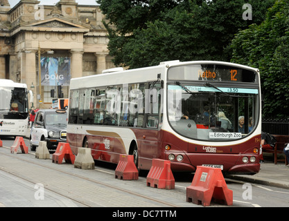 Lothian Buses, Edinburgh. The single decker bus pictured here on Princes Street Edinburgh where tram lines have been layed Stock Photo