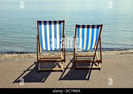 Two blue and white stripped empty deckchairs on Southend seafront Stock Photo