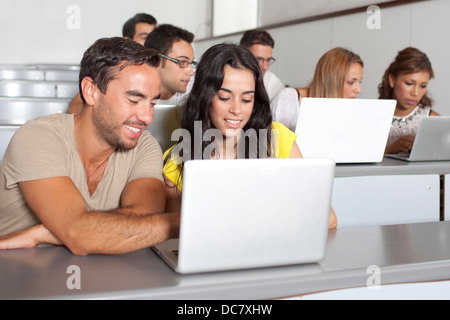 Students studying with laptops in class room Stock Photo