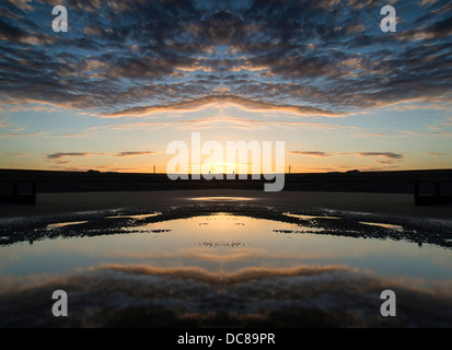 Beautiful sunrise reflected in low tide water pools on beach landscape Stock Photo