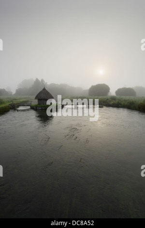 Fisherman's hut and eel traps across the River Test on the Leckford Estate at Longstock. Hampshire. England. UK. Stock Photo