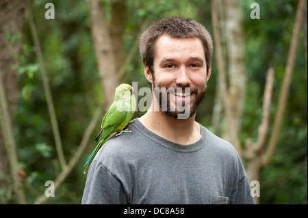 Tourist with parakeet, Birds of Eden, Plettenberg Bay, South Africa Stock Photo