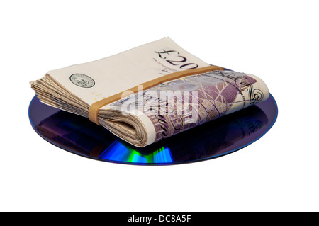 Money folded on top of a CD or DVD Stock Photo