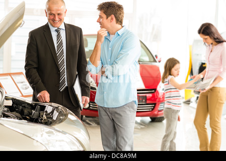 Car salesman showing the engine of the car Stock Photo