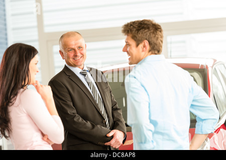 Customers talking with car agent in showroom Stock Photo