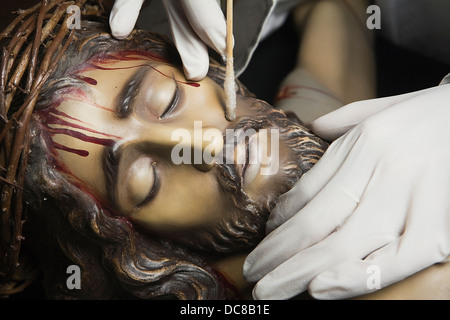 Cleaning with isopo in the face of a wood sculpture, Andalusia, Spain Stock Photo
