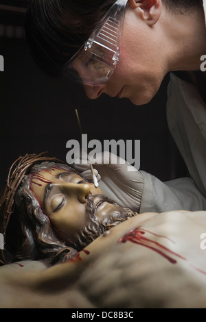 Cleaning of the face of a wooden sculpture of Christ with an isopo impregnated with dimethylformamide, Andalusia, Spain Stock Photo