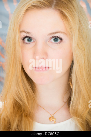 Young blond female teenager looking at camera with serious expression Stock Photo