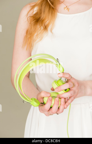 Closeup of young blond female teenager with green headphones Stock Photo