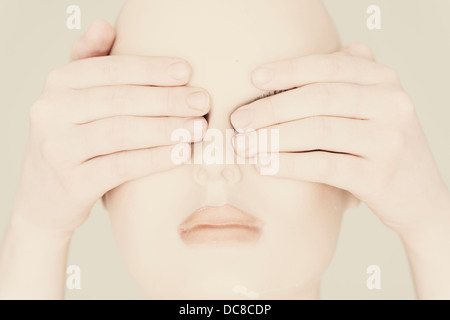 Head of mannequin with human hands covering the eyes Stock Photo
