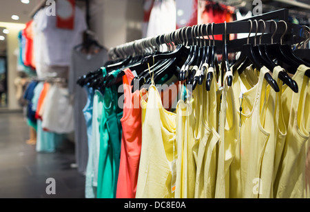 Fashionable colorful clothes on hangers in the store Stock Photo