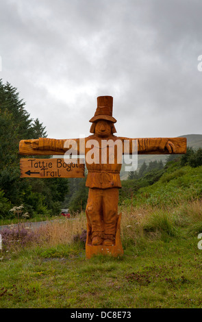 Wooden carved life-size wooden scarecrow type figure on the Isle of Skye, Scotland, pointing to Tattie Bogal Trail, UK Stock Photo