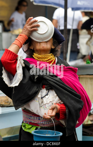 Ecuador, Quito area. Otavalo Market. Local woman in traditional highlands attire with cloth head covering and gold necklaces. Stock Photo