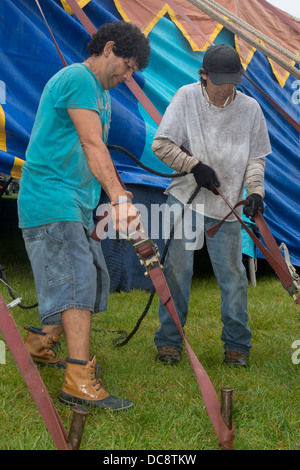Workers set up a tent in the rain for a performance of the Kelly Miller Circus. Stock Photo