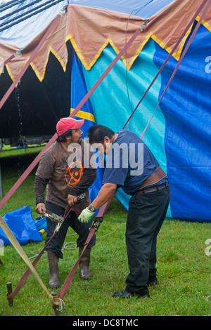 Workers set up a tent in the rain for a performance of the Kelly Miller Circus. Stock Photo