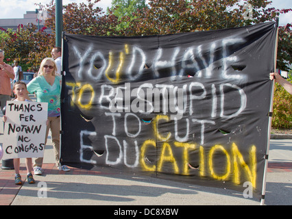 People with signs protesting North Carolina education cuts at a Moral Monday rally in Asheville, North Carolina, USA, on August Stock Photo