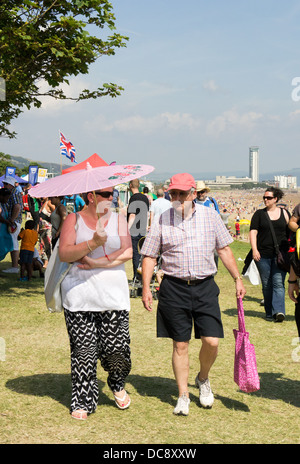 Elderly couple walking in the sunshine at Wales Airshow, Swansea, Summer 2013 Stock Photo