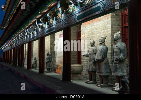 Statues along the illuminated wall of a building at night along the Lianhu Ancient City Wall; Xi'an, Shaanxi, China Stock Photo