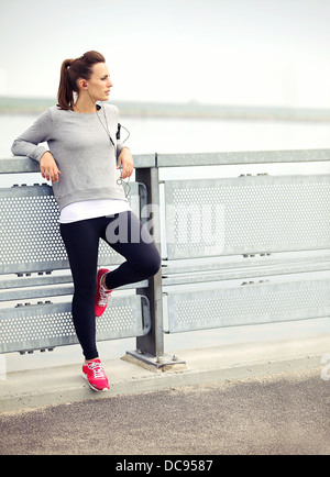 Female jogger resting while listening to mp3 music Stock Photo