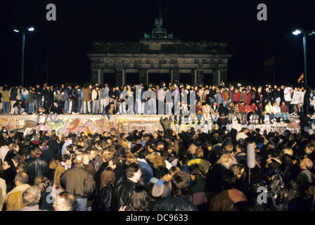 A huge crowd of people gathered on and in front of the Wall at Brandenburg Gate in Berlin on the evening of 10 November 1989. After the opening of some of the inner-German border crossings, some 50.000 GDR citizens visited West Berlin that night. Stock Photo