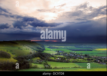 Dark moody skies form over bright fresh Spring countryside landscape Stock Photo