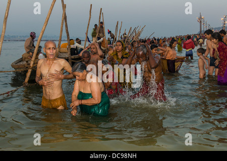 Crowds of people taking a bath in the Sangam, the confluence of the rivers Ganges, Yamuna and Saraswati, Kumbha Mela mass Hindu Stock Photo