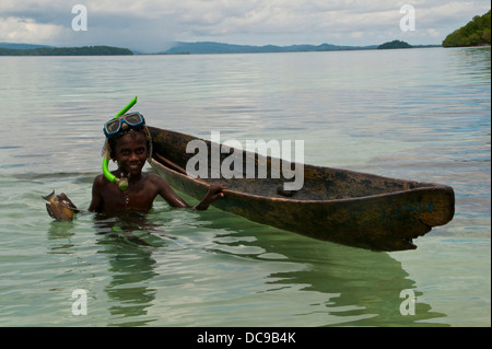 Boy fishing with his canoe and harpoon Stock Photo