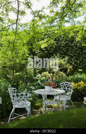 White metal garden table and chairs in a residential backyard Stock Photo