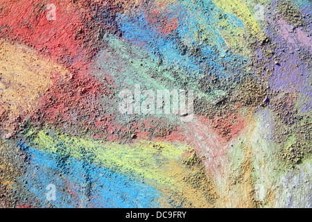 an abstract background of bright, rainbow colored sidewalk chalk smeared and drawn on the pavement Stock Photo