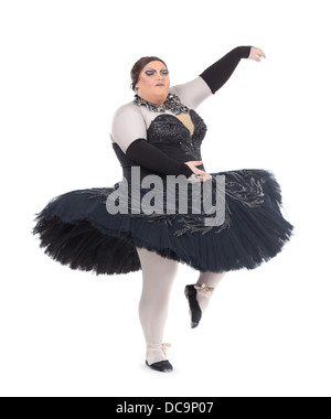 Overweight drag queen dancing in a tutu nimbly balancing on tiptoe with his foot raised in a fun caricature of a female ballet Stock Photo