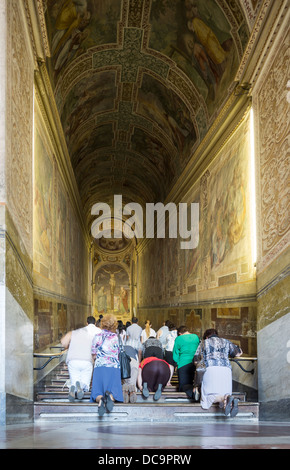 pilgrims climbing the Scala Sancta, holy steps or holy stairs, on their knees, Rome, Italy Stock Photo