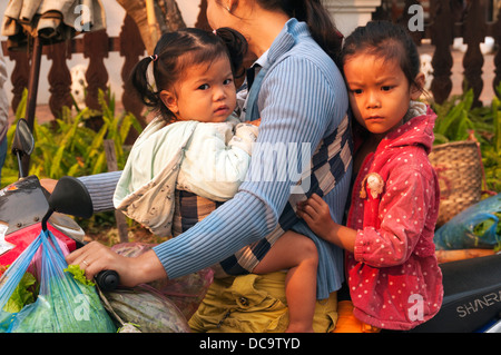 Elk209-1163 Laos, Luang Prabang, produce market, woman and children on motorbike Stock Photo