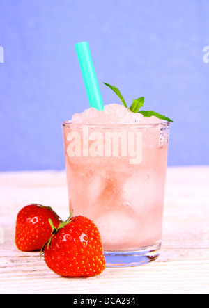 Strawberry slush in glass with straw on blue background, close up Stock Photo