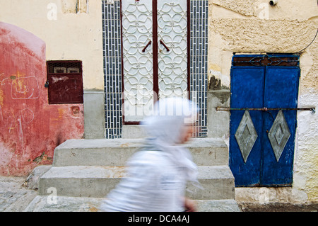 Woman walking on the streets of Moulay Idriss medina. Morocco Stock Photo