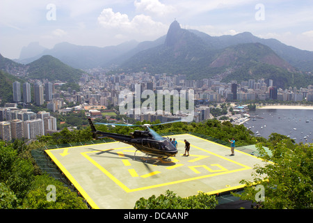 Tourists about to depart on a helicopter from the Sugar Loaf to take a tour of Rio de Janeiro, Brazil, February 2013. Stock Photo