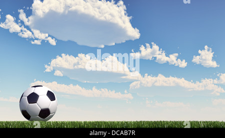 Soccer/football ball close up on grass lawn. Panoramic format. The ball stands on the left. Viewed from ground level. Stock Photo